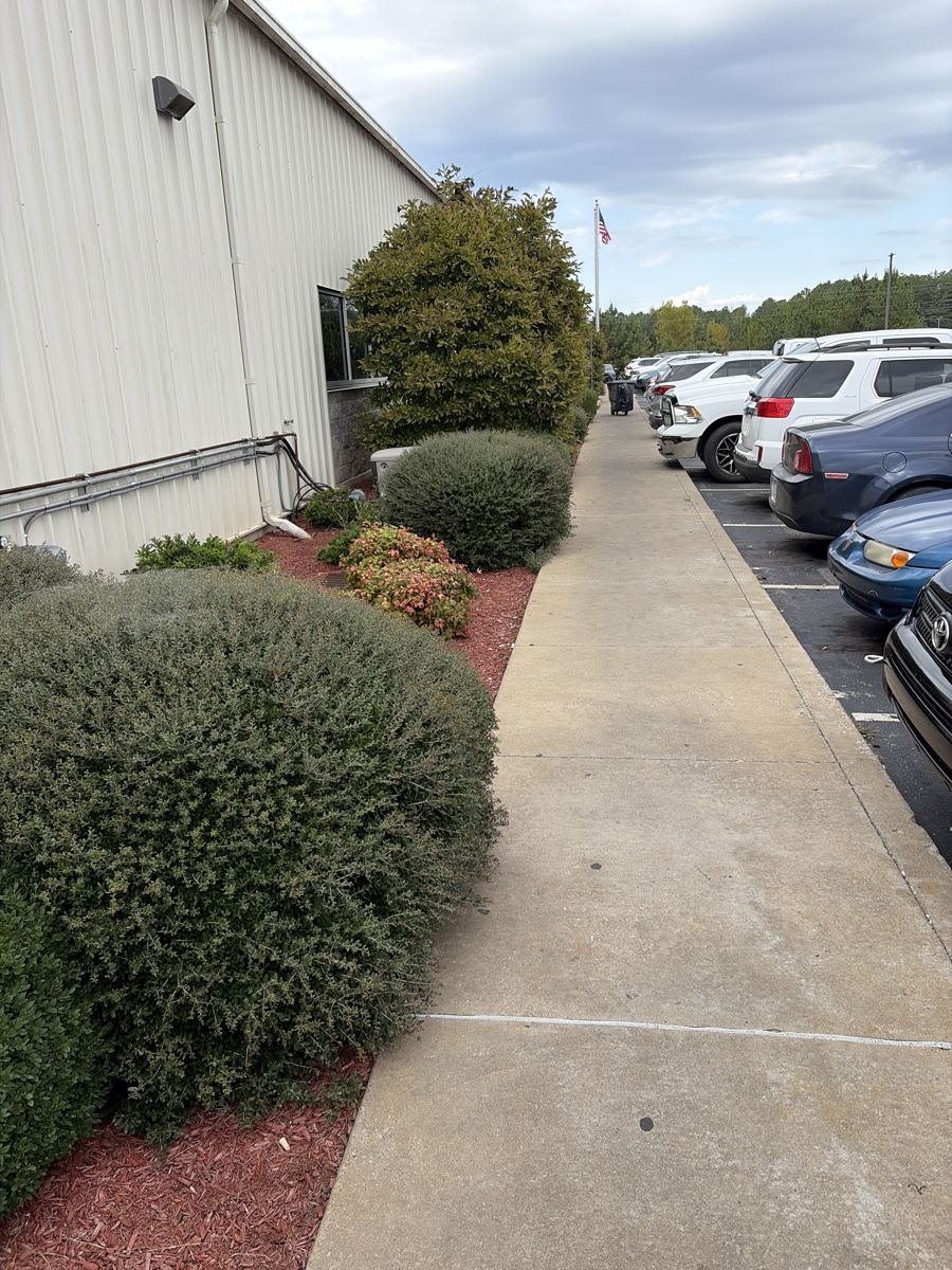 Side walkway at a West Tennessee industrial plant before exterior cleanup by OneFive Solutions